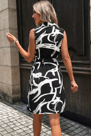 Black and white abstract print a-line dress with a belted waist and sleeveless design.