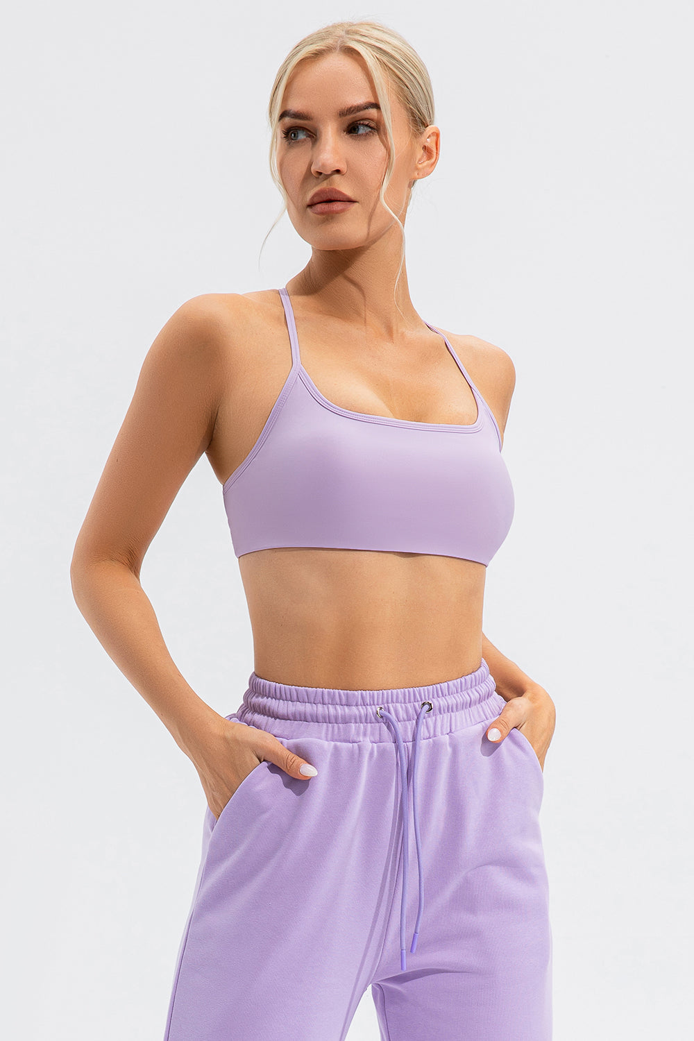 Lilac sports bra with spaghetti straps and a square neckline.