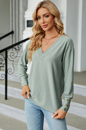 Light green diamond-textured V-neck blouse with button cuff detail