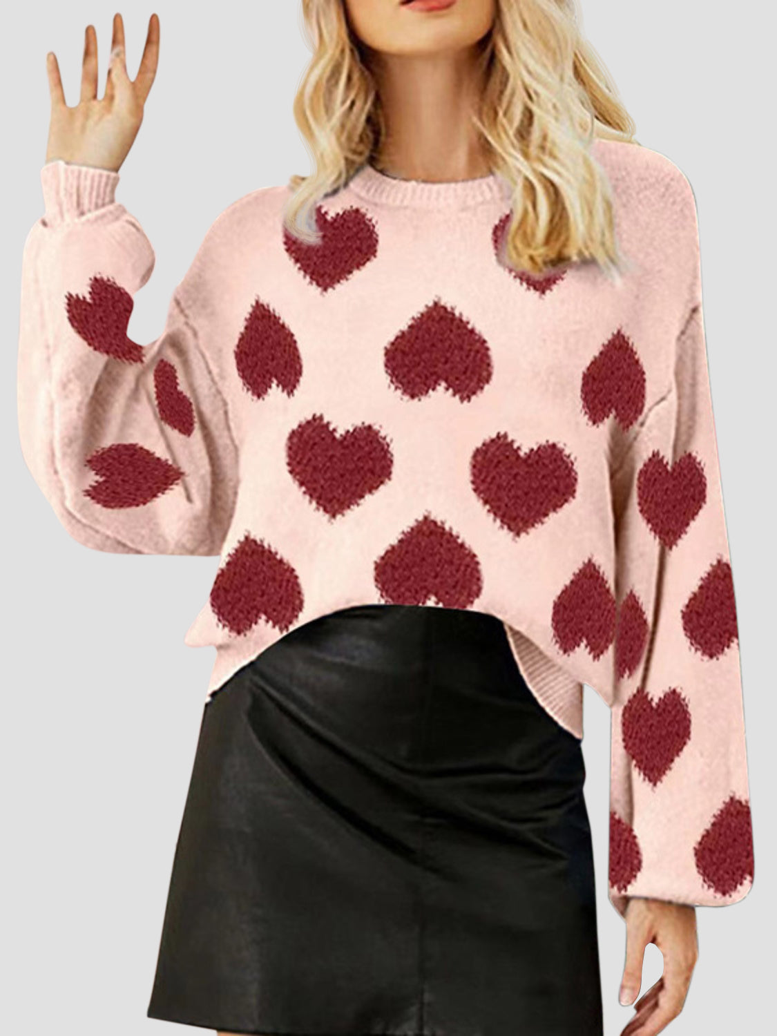 Watermelon pink knit sweater with allover heart motif and balloon sleeves.