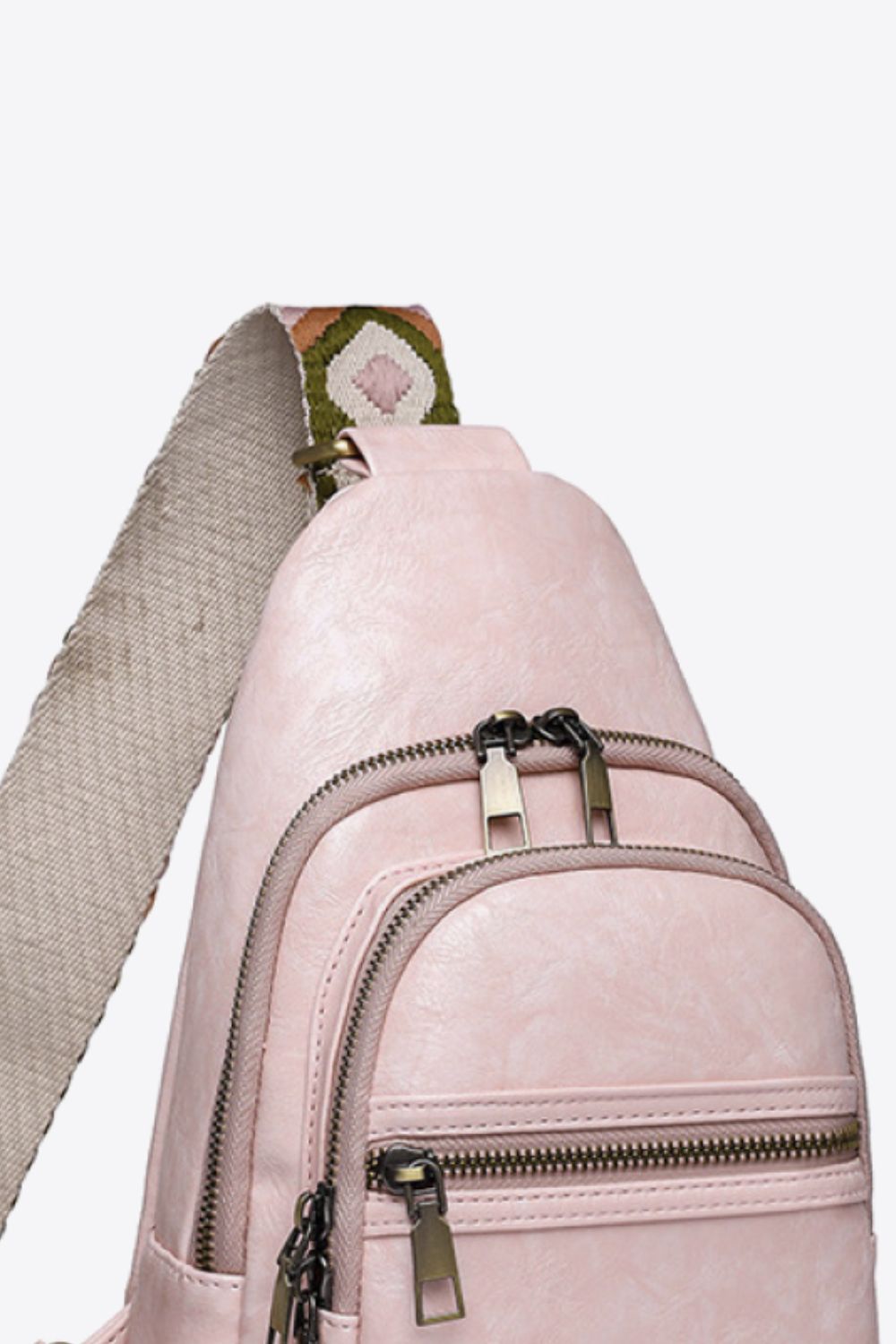 Blush pink sling bag with geometric strap and multiple zippered pockets