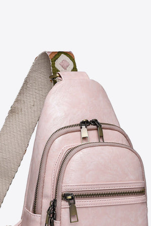 Blush pink sling bag with geometric strap and multiple zippered pockets