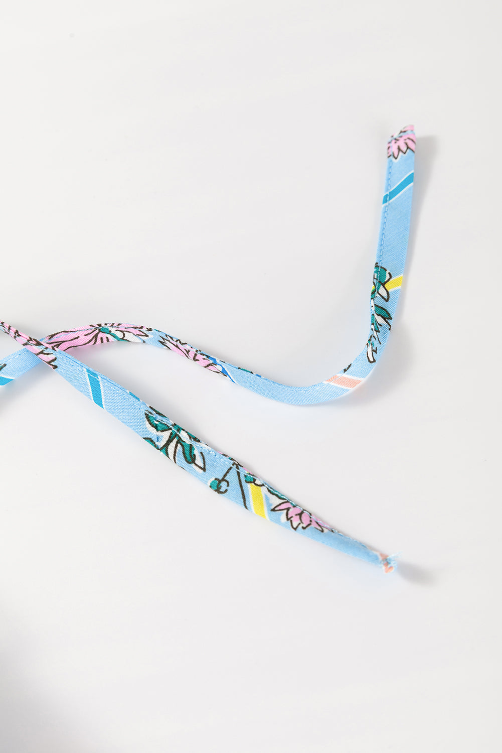 Sky blue floral print blouse with smocked yoke detail and tie straps.