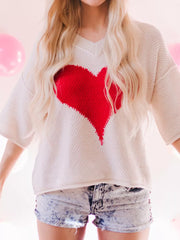 Beige v-neck knit sweater with a large red heart pattern, short sleeves.