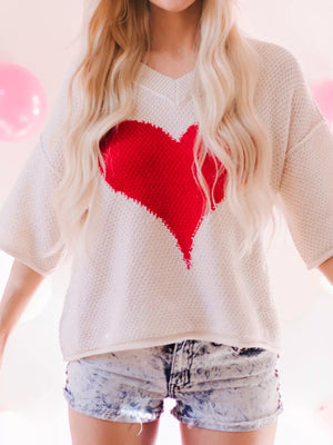 Beige v-neck knit sweater with a large red heart pattern, short sleeves.