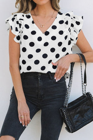 Polka dot V-neck blouse with flutter sleeves and ruffle trim.
