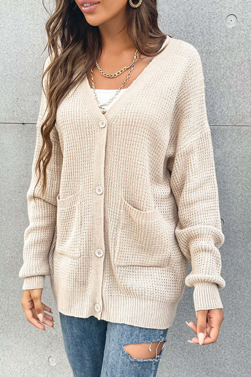 Beige waffle knit pocket cardigan with V-neck and button front.