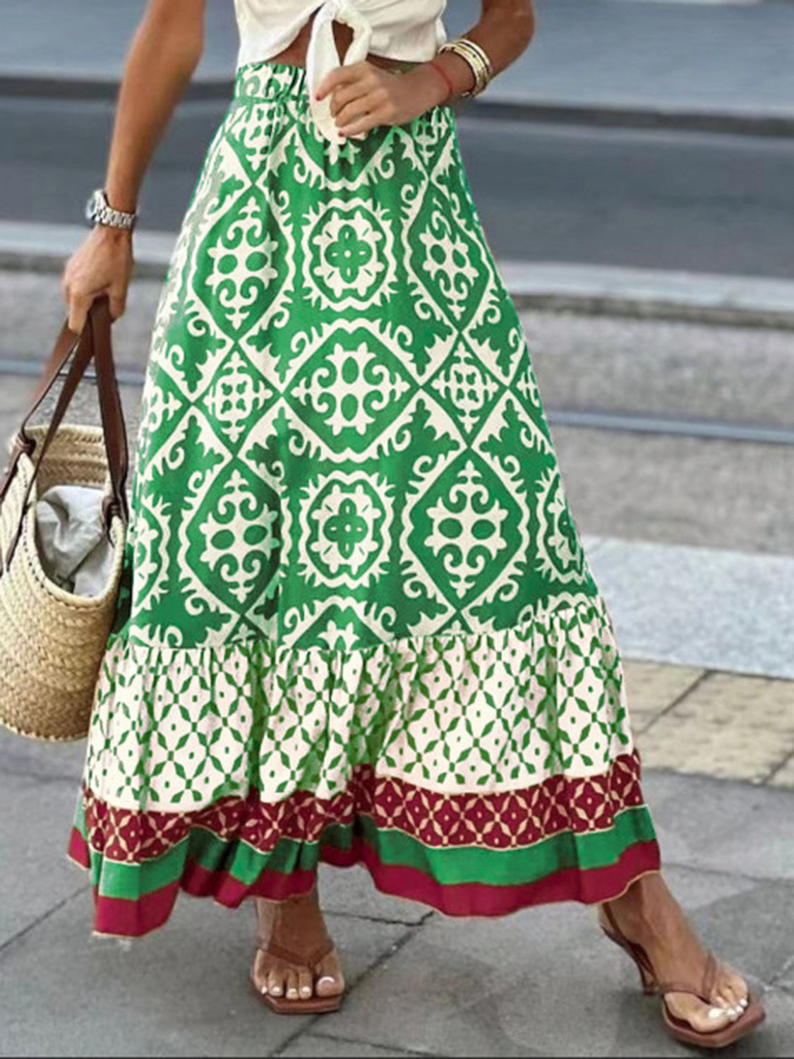 Tiered maxi skirt in green with medallion print, ruffle hem, and contrasting border details.
