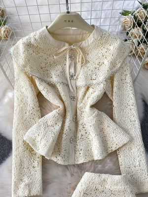 Luxe lace peplum top with bow neck and jeweled buttons, cream color.