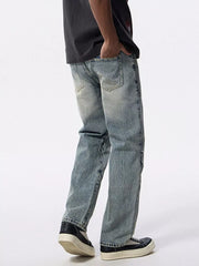 Men's light wash denim jeans with moto-inspired detailing on the side and a wide-leg fit.