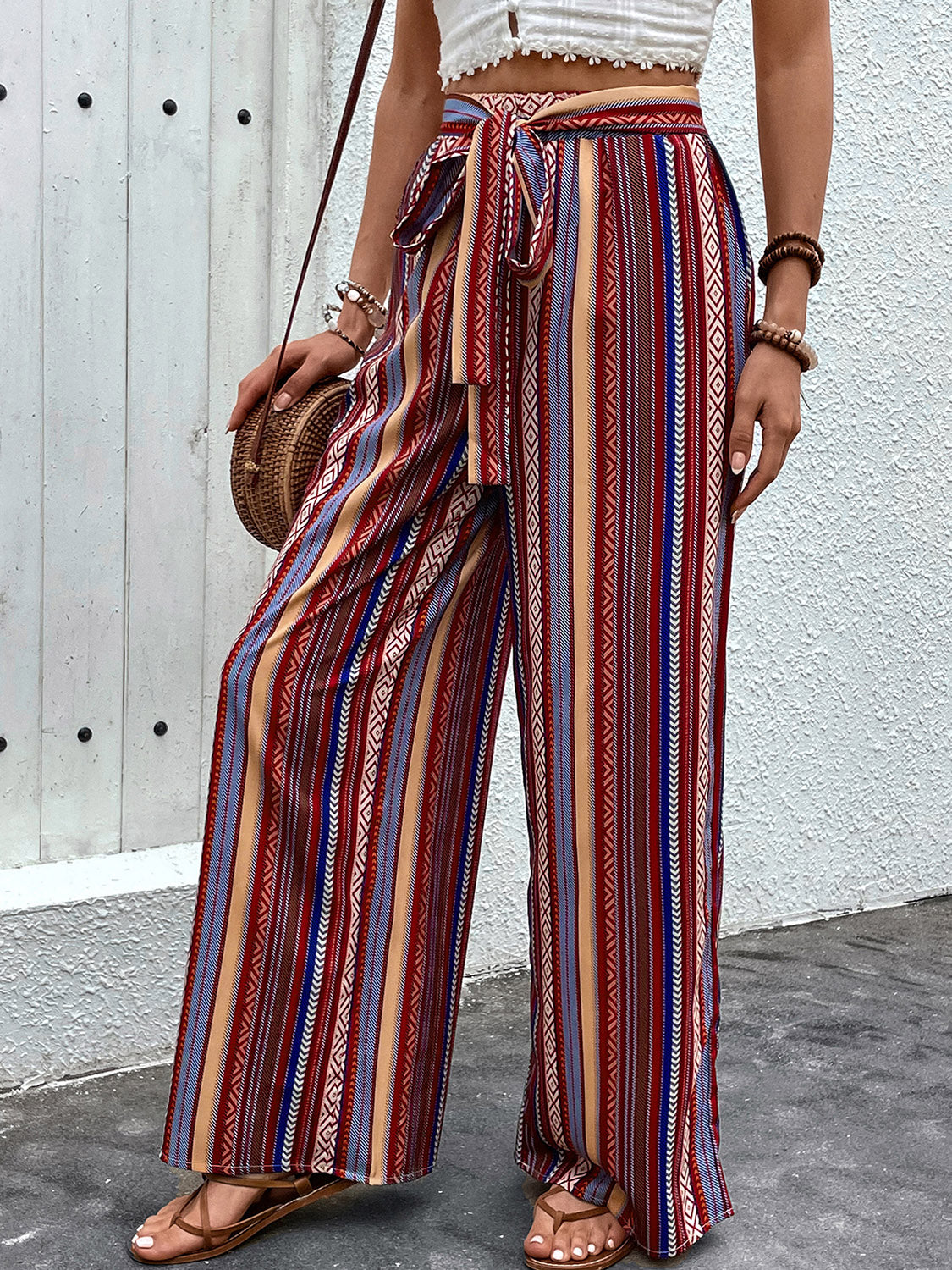 Bohemian stripe palazzo trousers in rust with a tie-waist and wide leg.