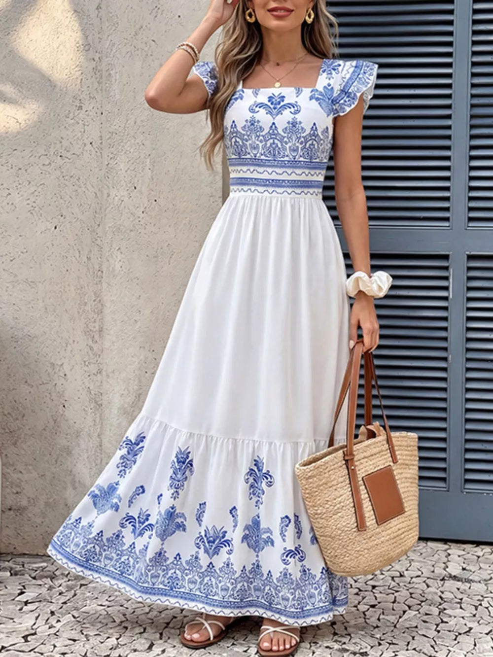 Printed square neck maxi dress with blue and white bohemian pattern, ruffled sleeves, and tiered skirt.