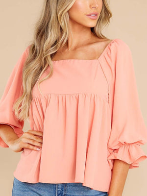 Watermelon pink babydoll blouse with square neckline and ruffled bell sleeves.