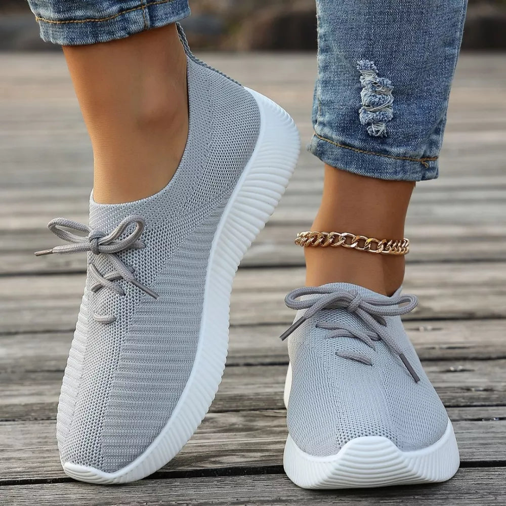 Gray breathable lace-up sneakers with white mid sole and laces.