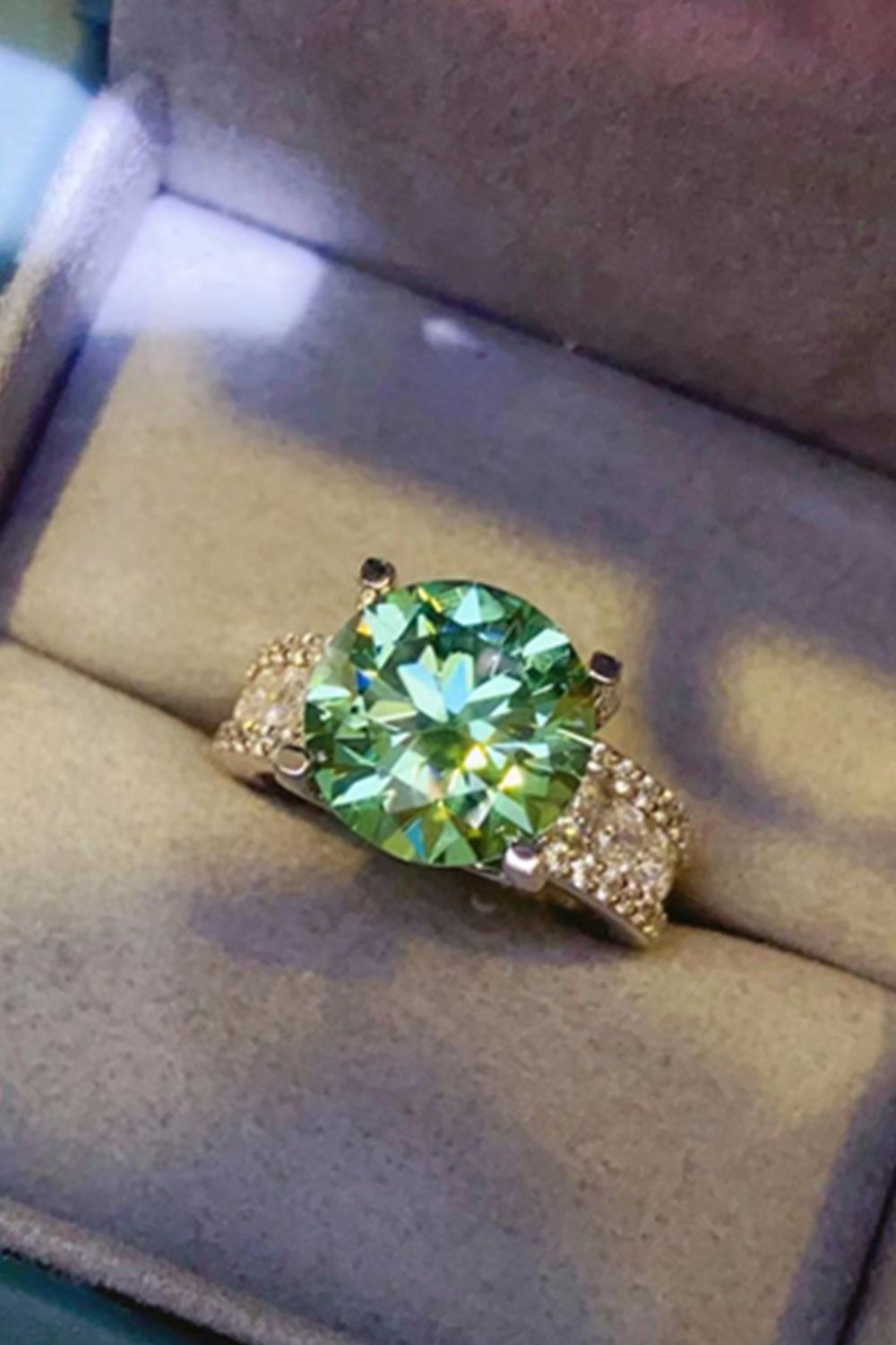 Light green moissanite pavé band ring with a large center stone.