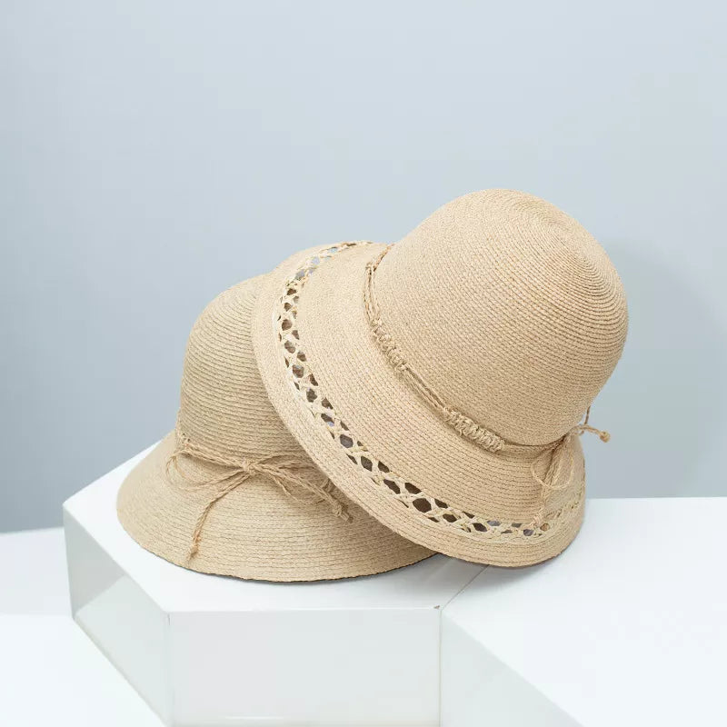Woven straw bucket hat in natural with twisted band detail and decorative bow.
