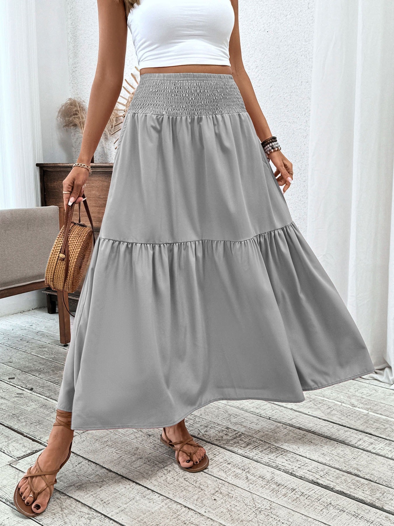 Gray ruffled smocked waist maxi skirt with tiered hem detail.