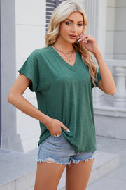 Dolman sleeve slouchy v-neck top in dark green, styled casually with denim shorts.