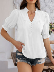 White textured puff sleeve blouse with ruffled neckline and button front.