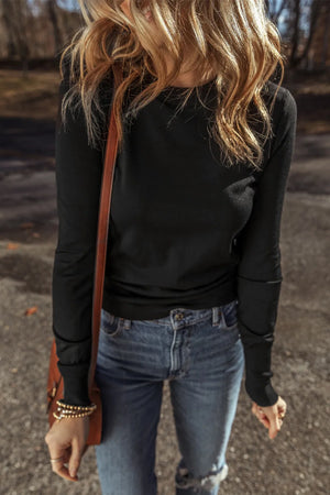 Black crewneck long sleeve knit top with subtle seam details on sleeves.
