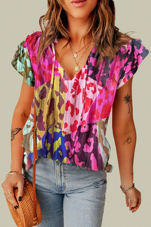 Floral patchwork blouse with ruffle sleeves and V-neck in hot pink and neon green colors.