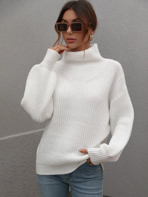 White ribbed knit turtleneck sweater with voluminous balloon sleeves and a relaxed fit.