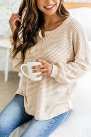 Waffle knit henley pullover in cream with button detail and crew neckline.