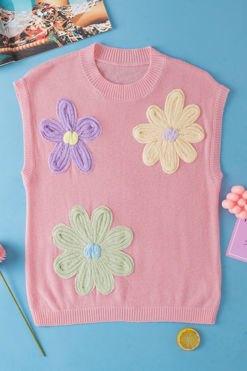 Pink knit sleeveless top with embroidered floral appliques in purple, yellow, and green.