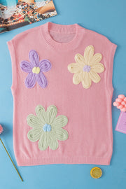 Pink knit sleeveless top with embroidered floral appliques in purple, yellow, and green.