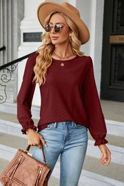 Burgundy textured puff sleeve blouse with ruffle cuffs and crew neck.