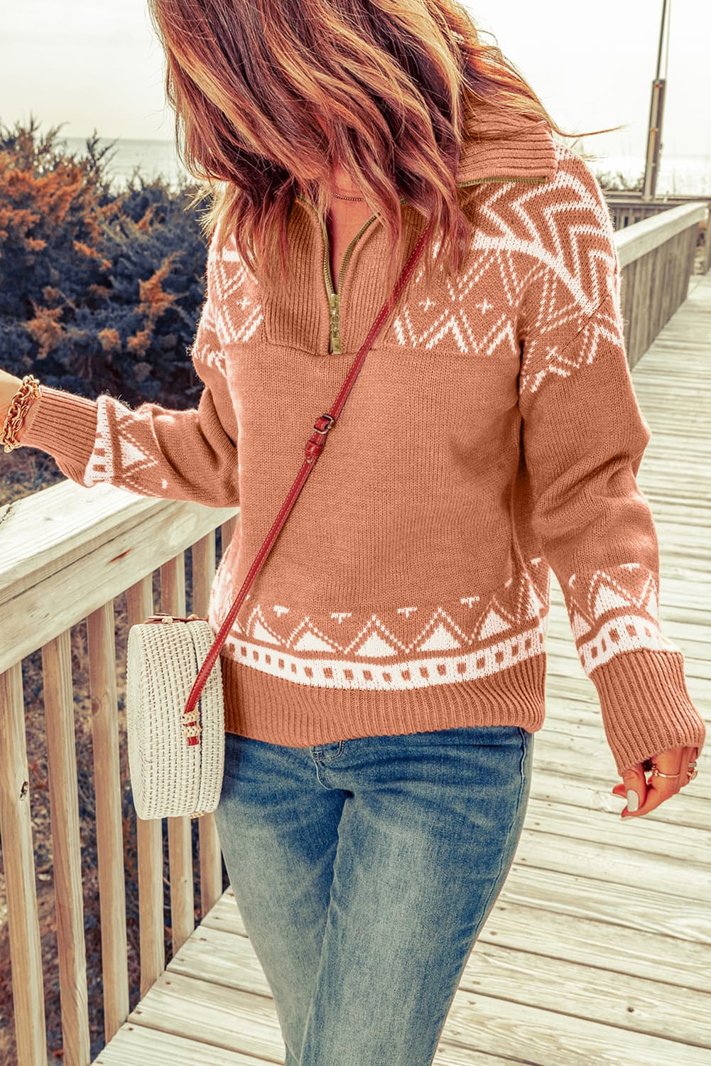 Geometric knit zip-neck pullover in rust orange with white fair isle pattern.