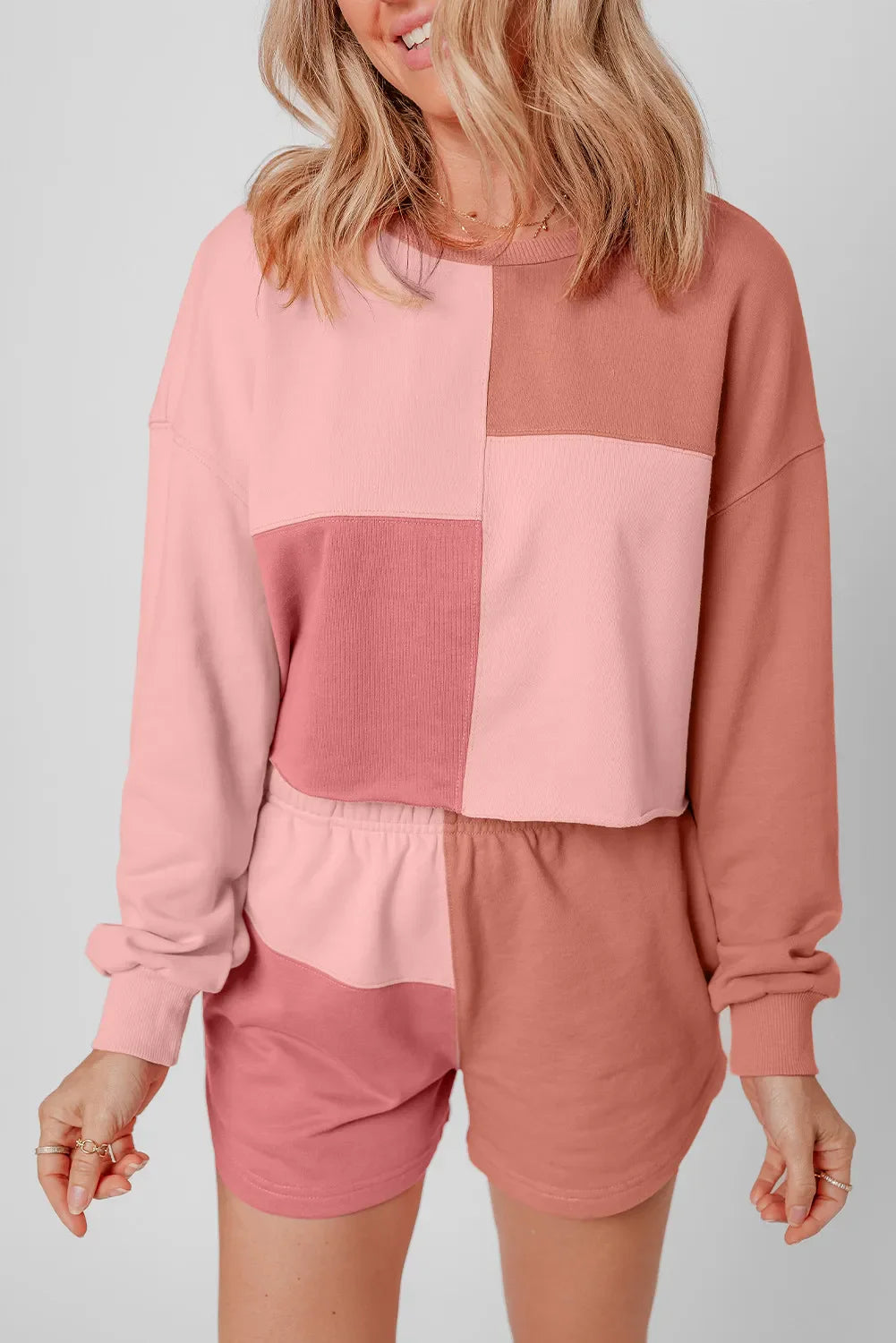 Colorblock lounge set with crewneck sweatshirt and shorts in pink and dusty rose hues.