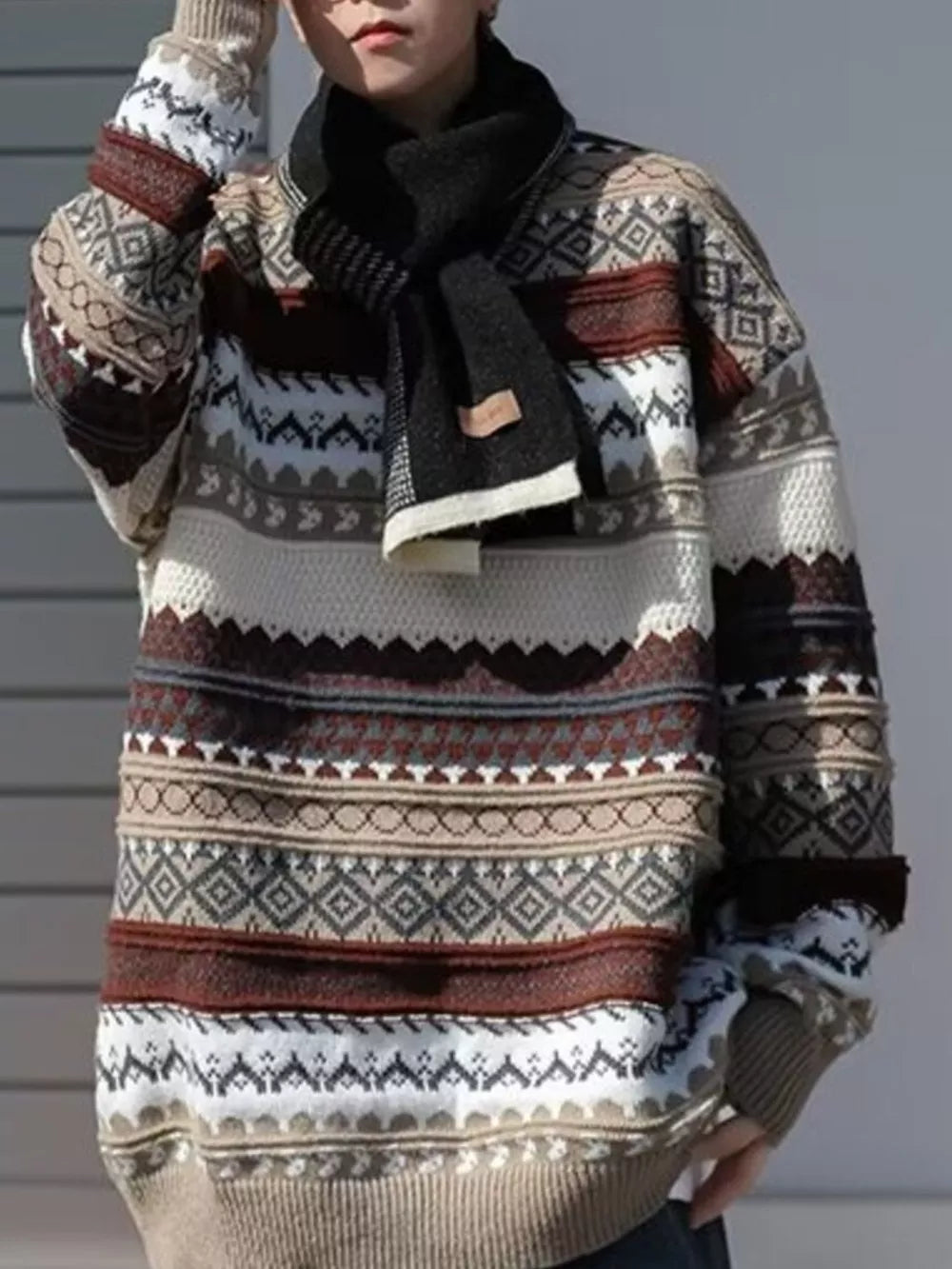Geometric knit sweater in gray and brown with a crew neck and long sleeves, styled with a scarf.