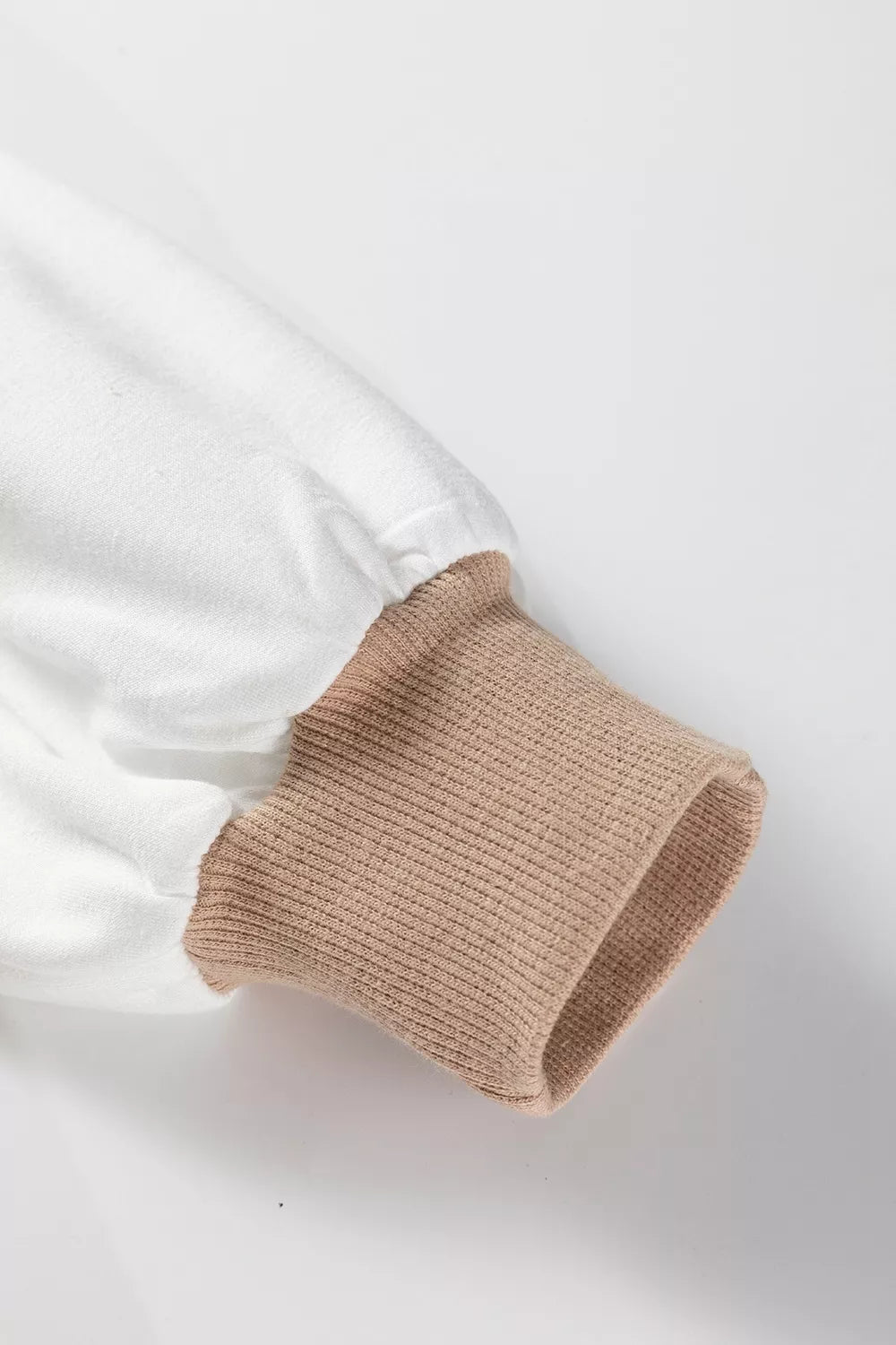 Chic colorblock sweatshirt with beige ribbed cuff and white sleeve detail.