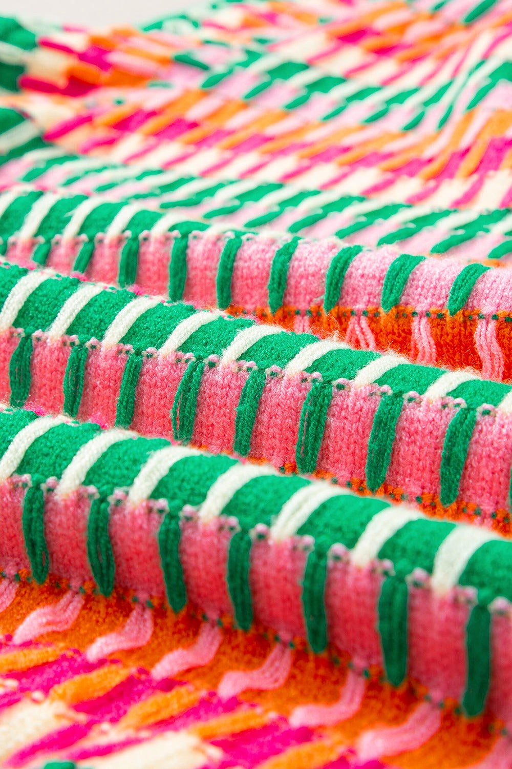 Geometric knit blouse with green, pink, and orange stripes, featuring flutter sleeves.