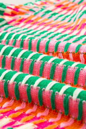 Geometric knit blouse with green, pink, and orange stripes, featuring flutter sleeves.