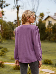 Dusty purple ruffled henley sleeve blouse with gathered shoulders.