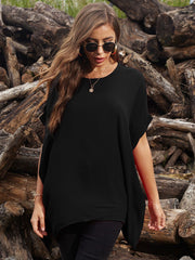 Black draped asymmetrical sleeve blouse with a relaxed fit, styled casually.