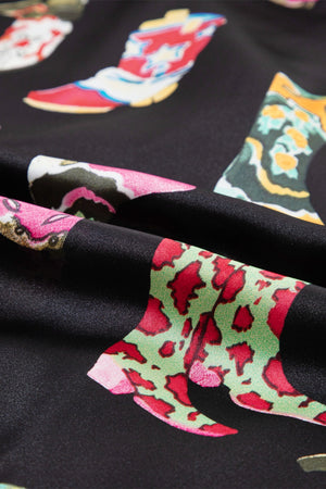 Black silk pajama set with a colorful boot print pattern.