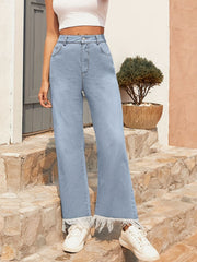Light wash denim flare jeans with a fringed hem.