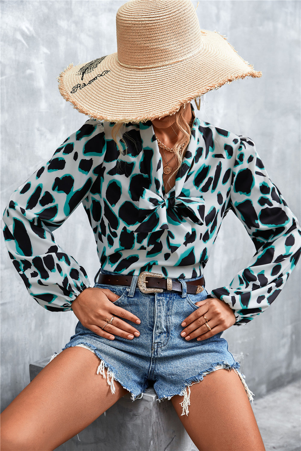 Abstract print pussy bow blouse with balloon sleeves in black, white, and teal.