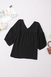 Black textured gauze blouse with V-neck and gathered puff sleeves.