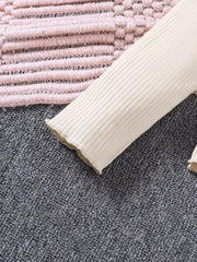Apricot ribbed long sleeve top with ruffled hem detail.