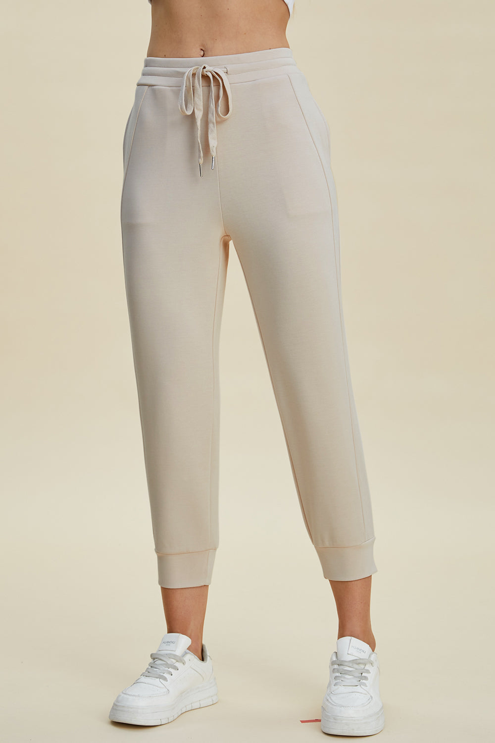 Beige joggers with drawstring waist and cuffed ankles