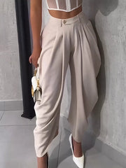 Light Khaki sculptural pleated high-waisted pants with button detail.