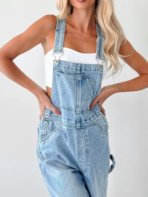 Light wash denim overalls with wide straps, bib pocket, and button side details.