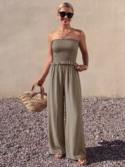 Smocked strapless olive green wide-leg romper with frill detail and wide legs.