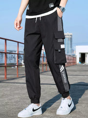 Black cargo joggers with adjustable waist, cuffed ankles, and stylish gray panel accents.