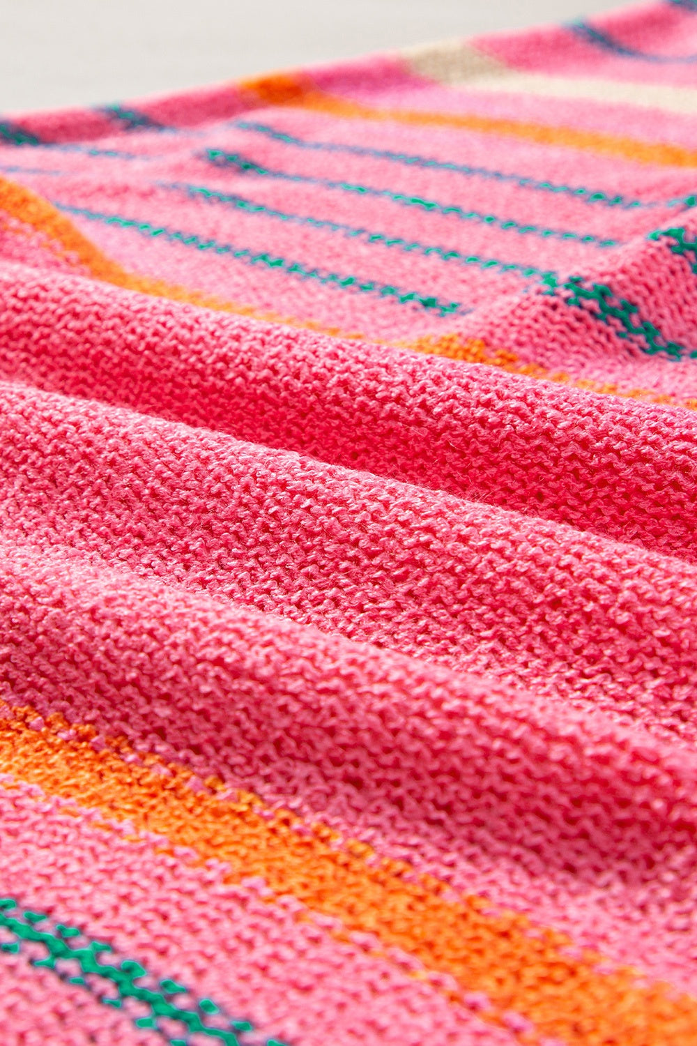 Colorblock sleeve knit pullover in strawberry pink with horizontal stripes of green and orange.
