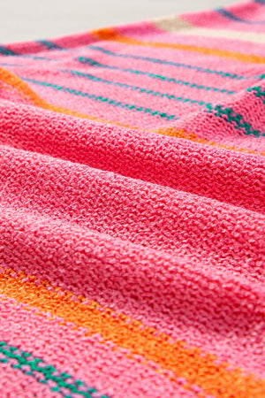 Colorblock sleeve knit pullover in strawberry pink with horizontal stripes of green and orange.